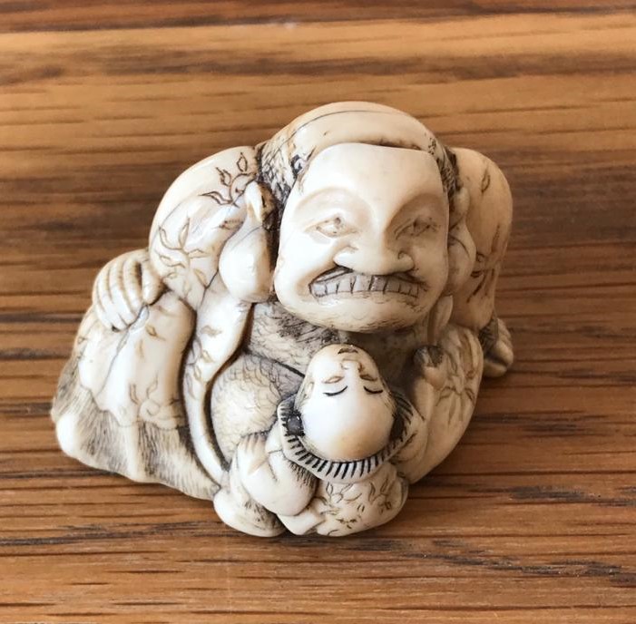 Netsuke masked man with curious child 1.jpg